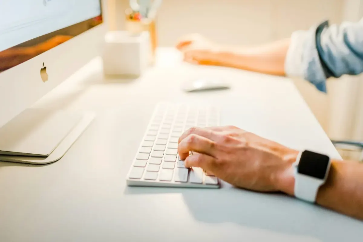 Person typing at a desktop computer while reviewing mobile game user acquisition test priorities Person typing at a desktop computer while reviewing mobile game user acquisition test priorities